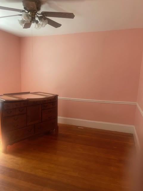 interior space with wood finished floors, baseboards, and ceiling fan