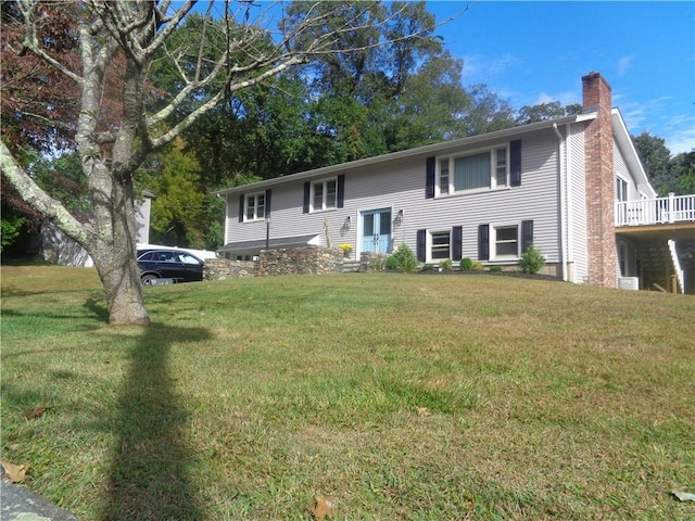 bi-level home with a chimney and a front yard