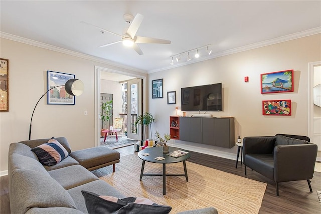 living area with rail lighting, wood finished floors, ceiling fan, and ornamental molding