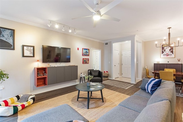 living room with ceiling fan with notable chandelier, crown molding, wood finished floors, and visible vents