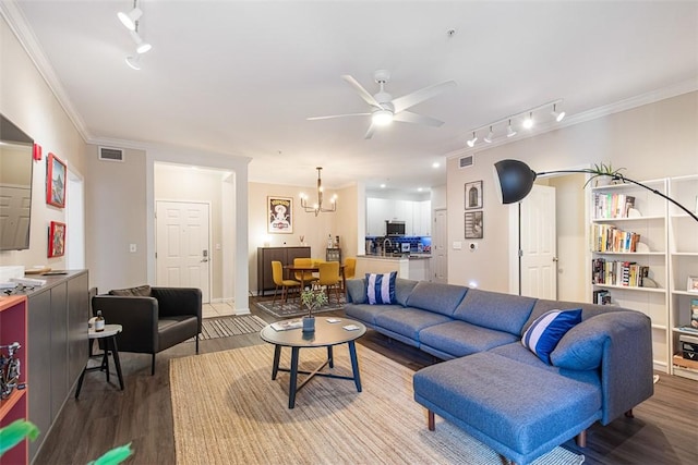 living room featuring visible vents, ceiling fan with notable chandelier, crown molding, and wood finished floors