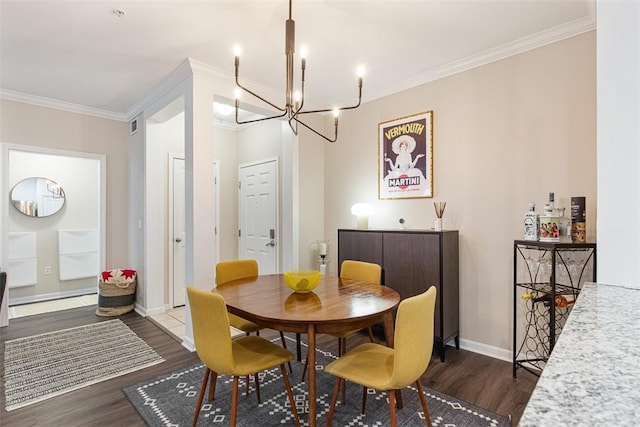 dining area featuring dark wood-type flooring, a notable chandelier, and crown molding