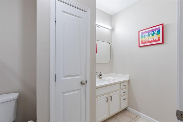 bathroom with tile patterned flooring, toilet, vanity, and baseboards