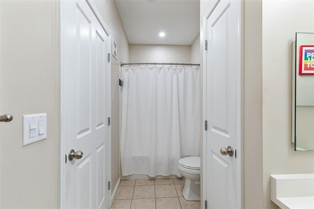 bathroom featuring tile patterned flooring, toilet, a shower with curtain, and a sink