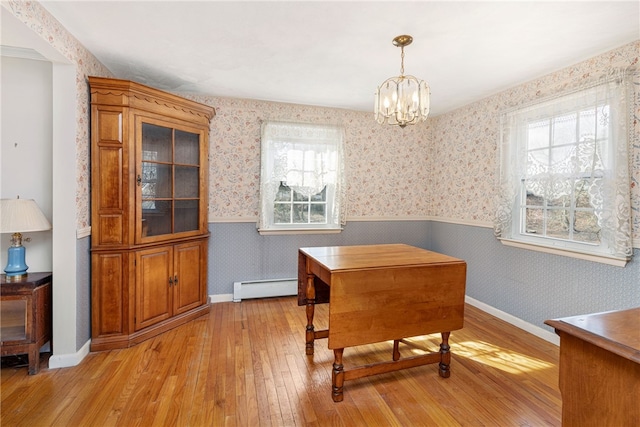 dining room featuring a wainscoted wall, light wood-style floors, an inviting chandelier, wallpapered walls, and a baseboard radiator