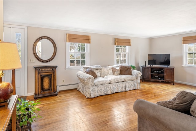 living room featuring light wood finished floors, crown molding, baseboards, and a baseboard radiator