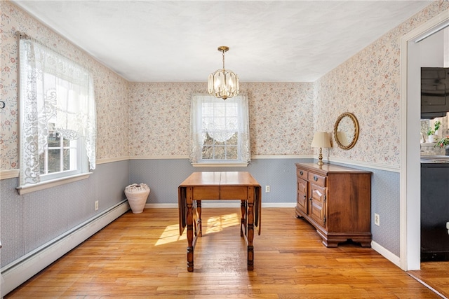 dining room with wallpapered walls, baseboard heating, wainscoting, an inviting chandelier, and hardwood / wood-style flooring