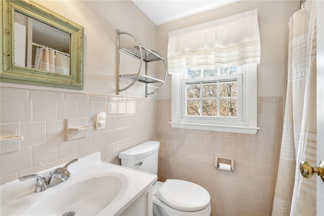 full bath with a wainscoted wall, toilet, tile walls, and vanity