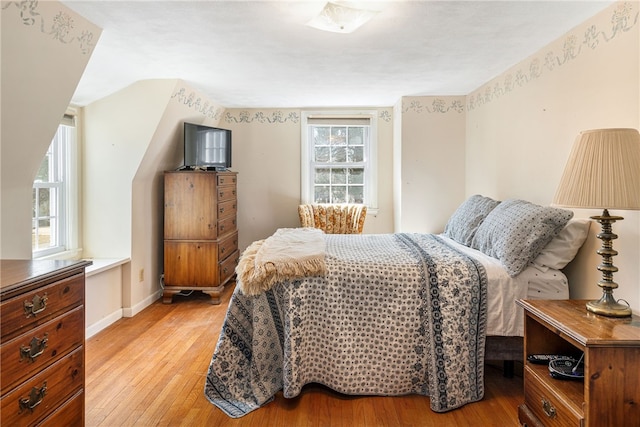 bedroom with baseboards and light wood finished floors