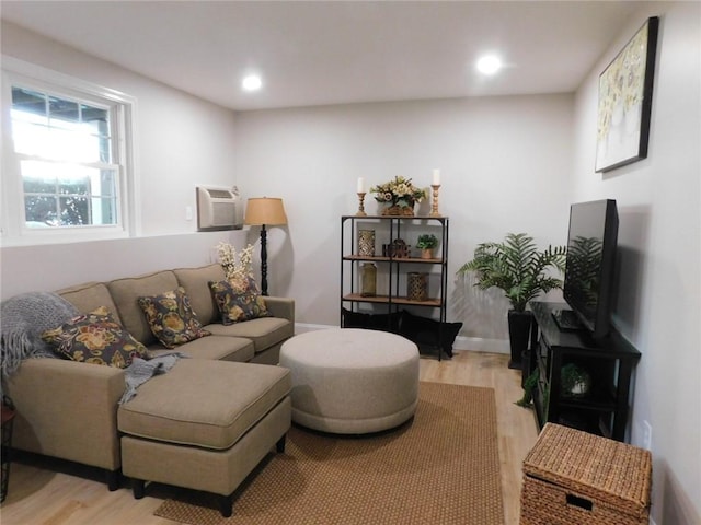 living area with recessed lighting, baseboards, light wood-style flooring, and a wall mounted AC