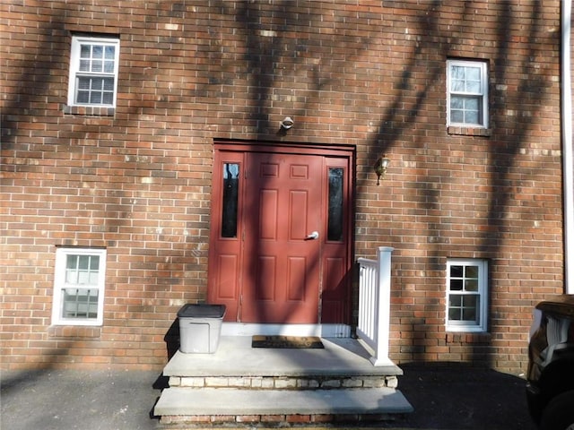 doorway to property featuring brick siding