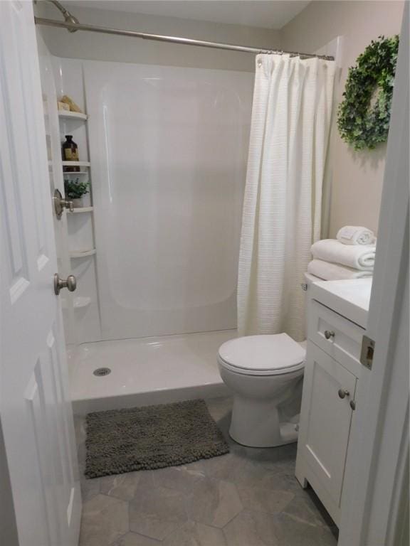 full bathroom featuring a shower stall, toilet, and vanity