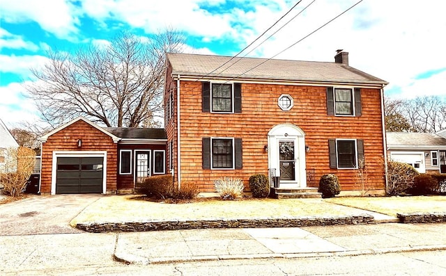 view of front of property with concrete driveway, an attached garage, and a chimney