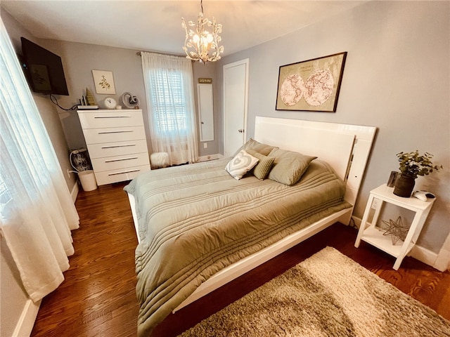 bedroom with a notable chandelier and wood finished floors