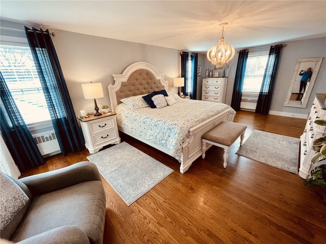 bedroom with dark wood-type flooring, radiator, and a chandelier