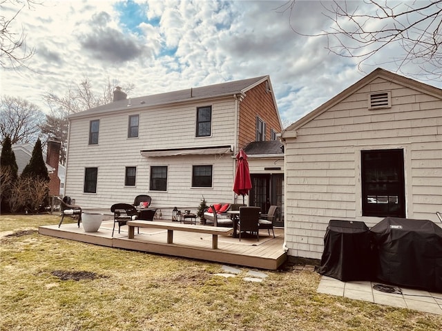 back of house with a yard, a chimney, and a wooden deck