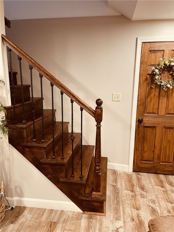 stairs featuring wood finished floors and baseboards