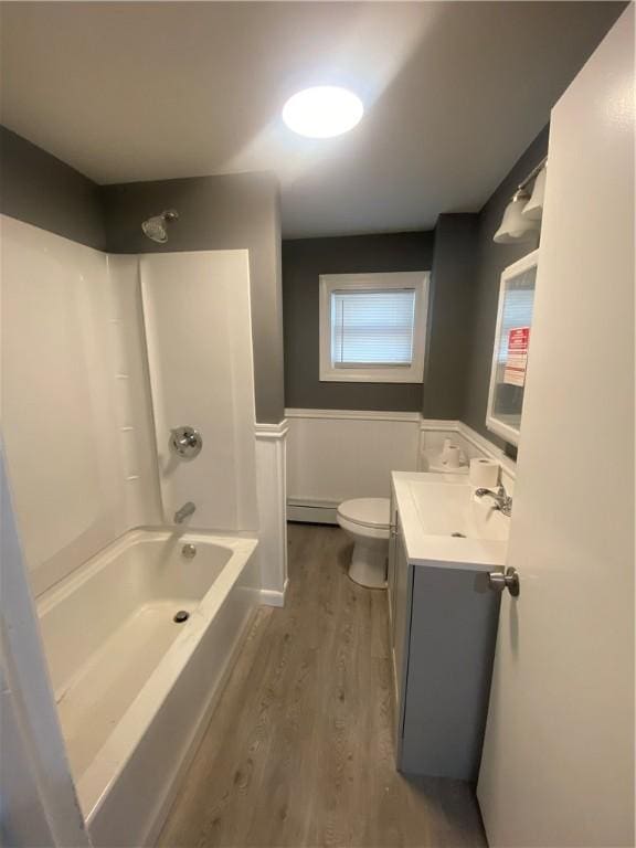 bathroom with toilet, a baseboard heating unit, wood finished floors, wainscoting, and vanity