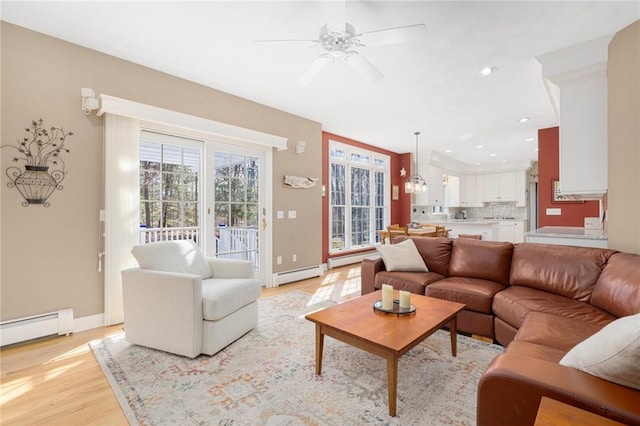 living room featuring recessed lighting, light wood-style floors, a ceiling fan, and a baseboard radiator