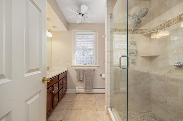 full bathroom featuring baseboard heating, a stall shower, vanity, and a ceiling fan