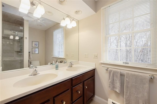 bathroom featuring a sink, toilet, a healthy amount of sunlight, and a ceiling fan