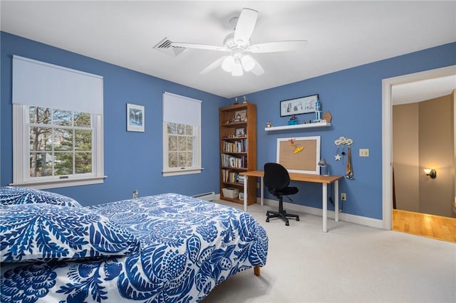 carpeted bedroom featuring baseboard heating, ceiling fan, and baseboards