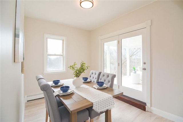 dining space with light wood-style floors and baseboards