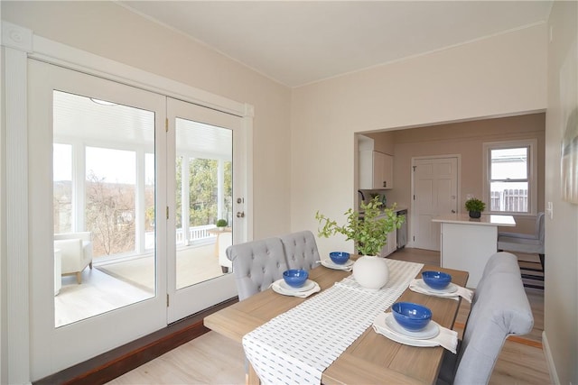 dining area featuring light wood finished floors and a healthy amount of sunlight