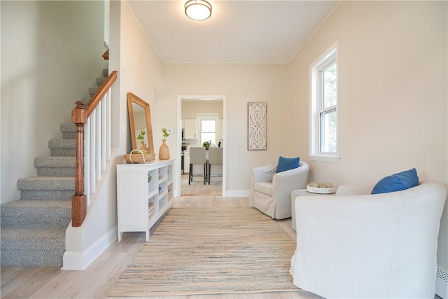 interior space featuring stairs, baseboards, light wood-type flooring, and baseboard heating