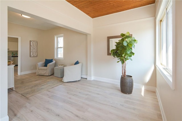 living area featuring wood ceiling, light wood-type flooring, and baseboards