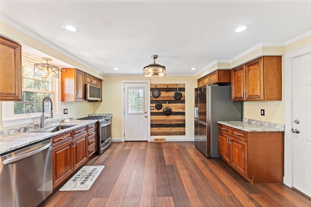 kitchen featuring dark wood-style floors, a healthy amount of sunlight, appliances with stainless steel finishes, and a sink