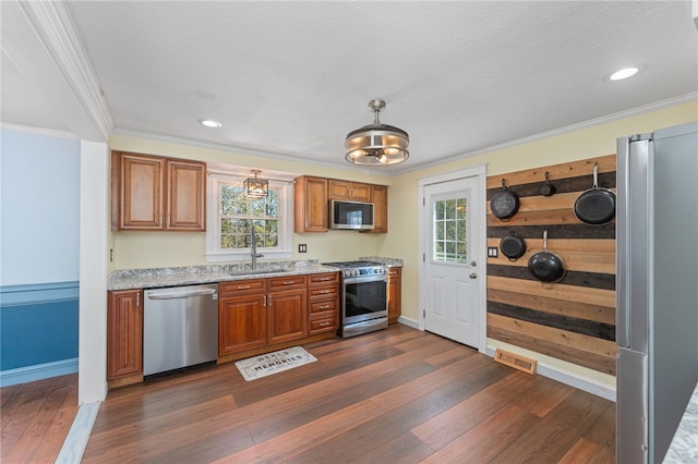 kitchen featuring a sink, brown cabinetry, dark wood finished floors, and stainless steel appliances