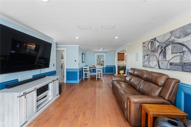 living area with recessed lighting, wainscoting, light wood-style flooring, and crown molding