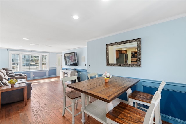 dining area with recessed lighting, crown molding, and hardwood / wood-style flooring