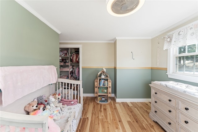 bedroom featuring baseboards, crown molding, and light wood-style floors