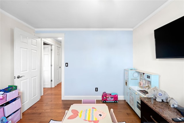 rec room featuring baseboards, wood finished floors, and ornamental molding