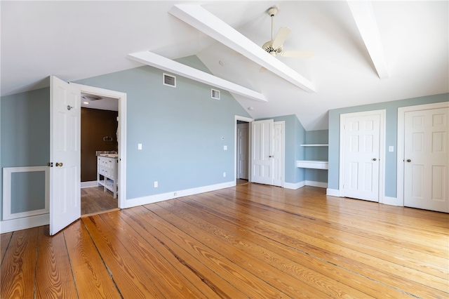 interior space featuring baseboards, visible vents, lofted ceiling with beams, ceiling fan, and light wood-style floors