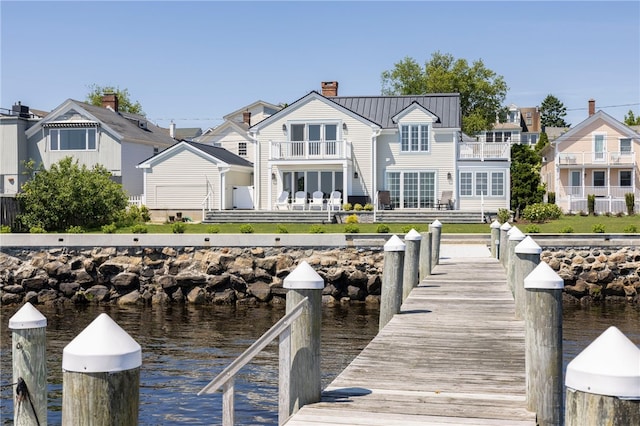 view of dock featuring a balcony, a residential view, and a water view