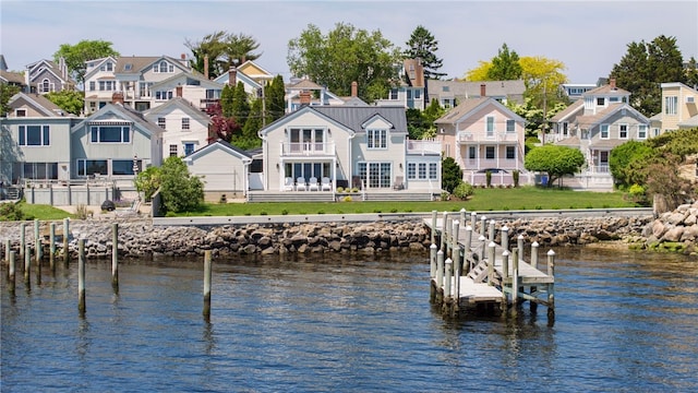 view of dock featuring a yard, a residential view, and a water view