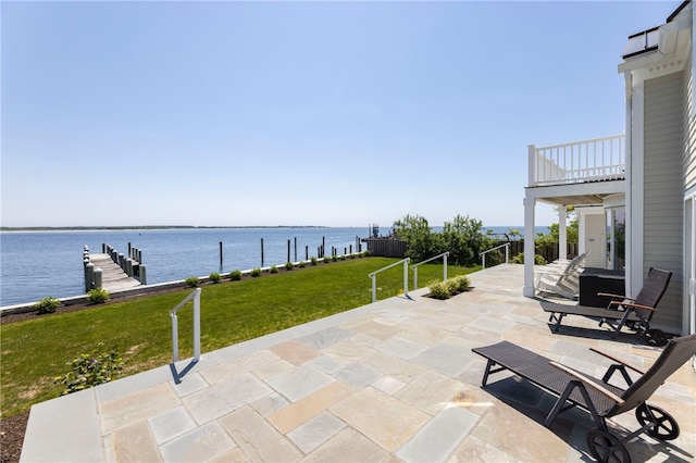 view of patio featuring a balcony, a water view, and a boat dock