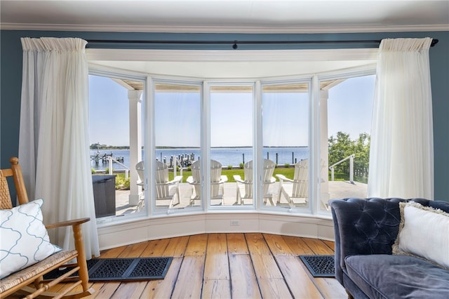 interior space with hardwood / wood-style flooring, crown molding, and a water view