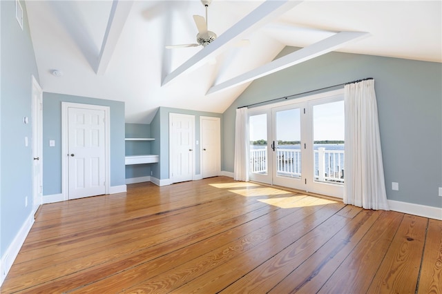 unfurnished living room featuring baseboards, vaulted ceiling with beams, light wood-type flooring, and a ceiling fan