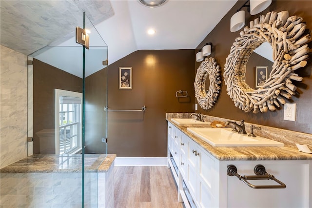 full bath featuring vaulted ceiling, wood finished floors, baseboards, and a sink