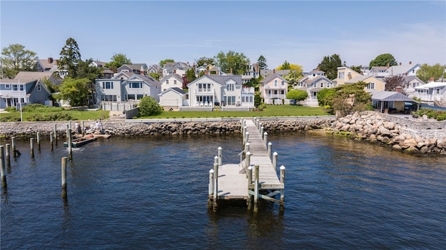 view of dock featuring a residential view, a lawn, and a water view