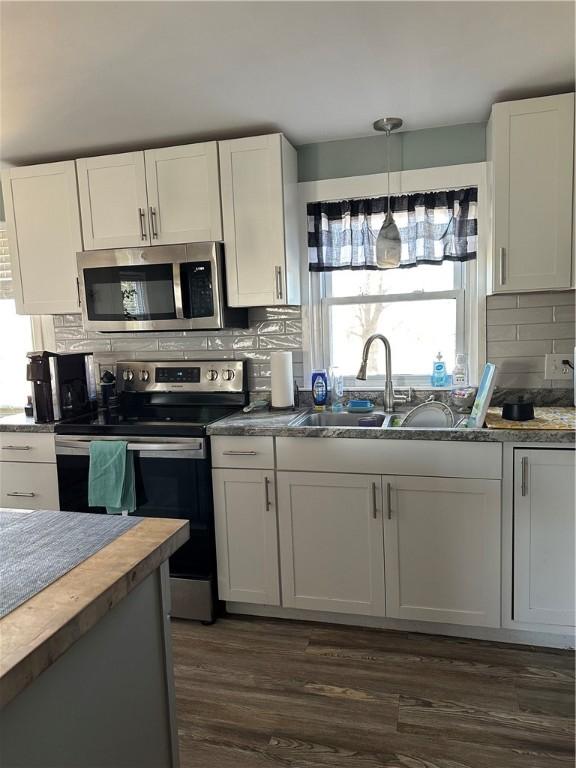 kitchen with a sink, decorative backsplash, appliances with stainless steel finishes, and white cabinetry