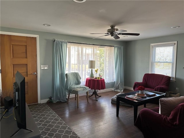 living room featuring wood finished floors, plenty of natural light, a ceiling fan, and baseboards