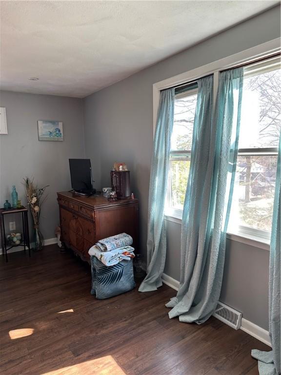 bedroom with visible vents, baseboards, and wood finished floors