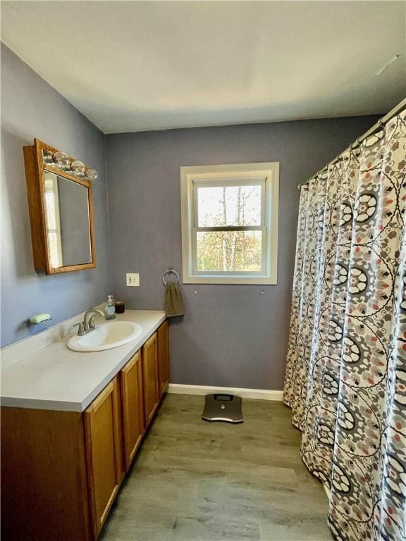 bathroom featuring baseboards, wood finished floors, and vanity