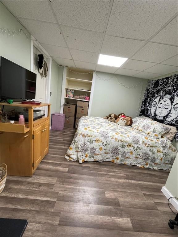 bedroom featuring wood finished floors and a drop ceiling