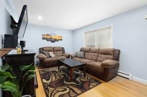 500 Kingstown Rd Unit 3B, Richmond, RI 02892 - living area with baseboard heating, wood finished floors, and baseboards